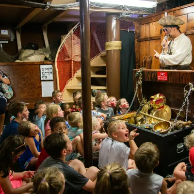 group of people watching pirate ship crew member telling stories