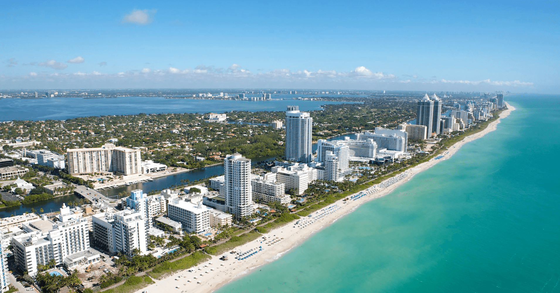 Aerial view of the emerald coast with beaches, high-rise buildings, and blue ocean.