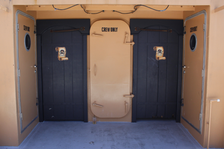 Three ship doors labeled 'Crew Only' with pirate-themed signs.