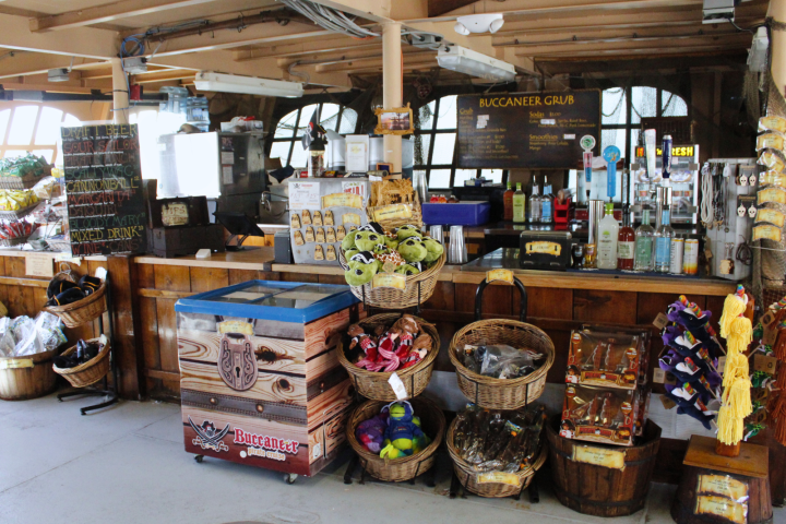 Pirate-themed snack bar with baskets of goods and a drink menu.