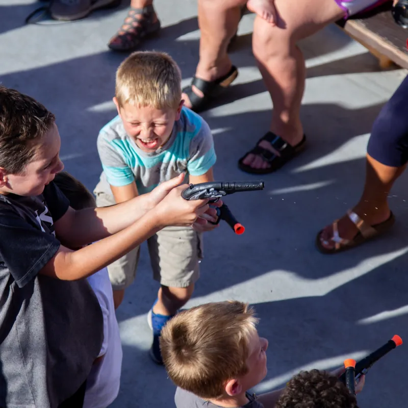 two little boys having a water gun fight on the Buccaneer