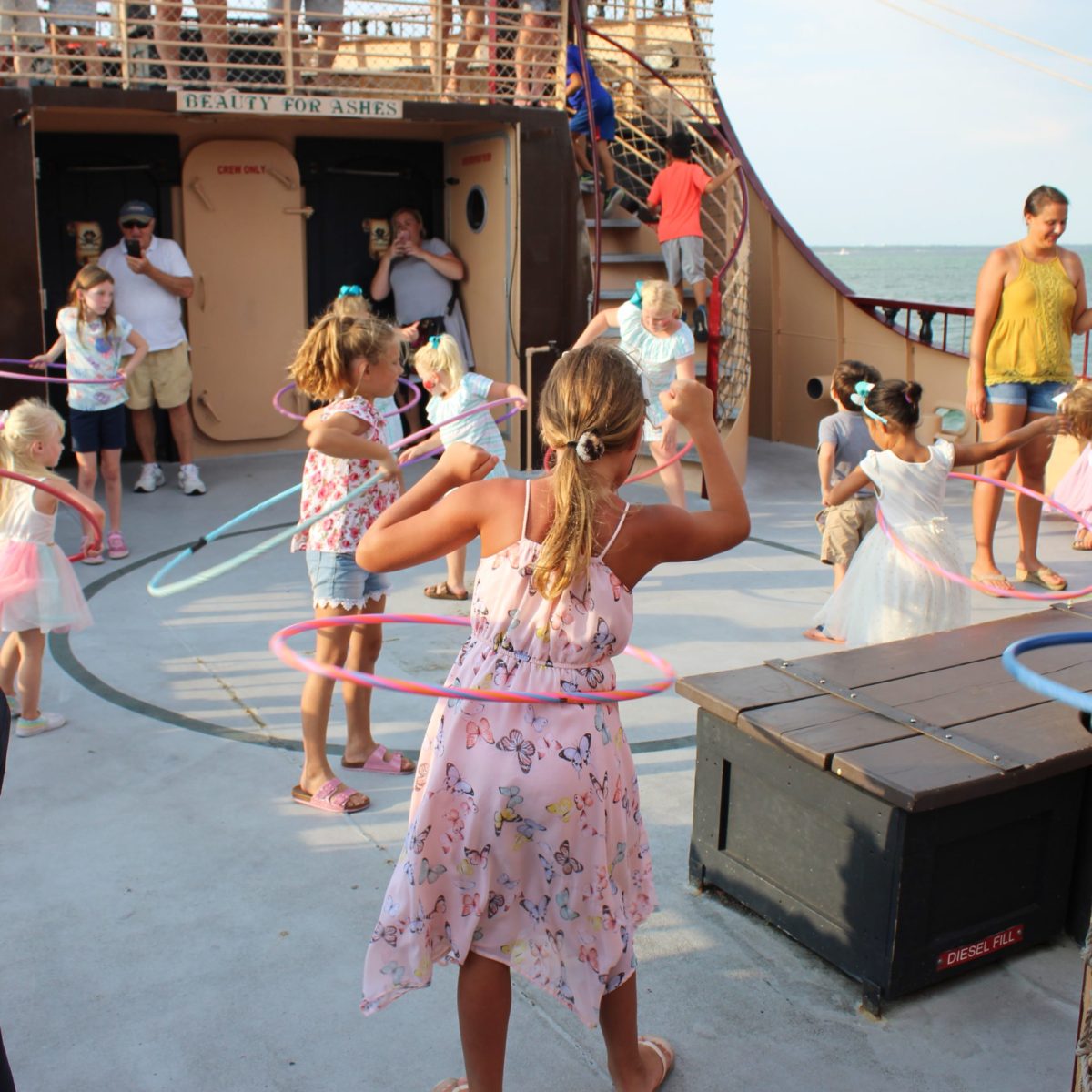 little girl hula hooping while people watch