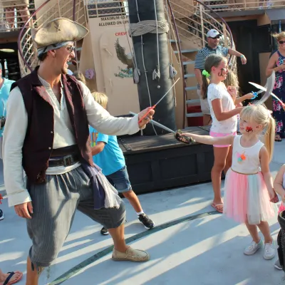 Pirate ship crew member and little girl sword fighting