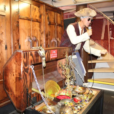 a pirate next to an overflowing treasure chest