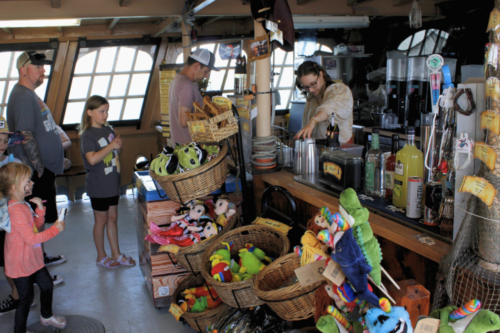 People shopping in a store with plush toys, drinks, and snacks on display.