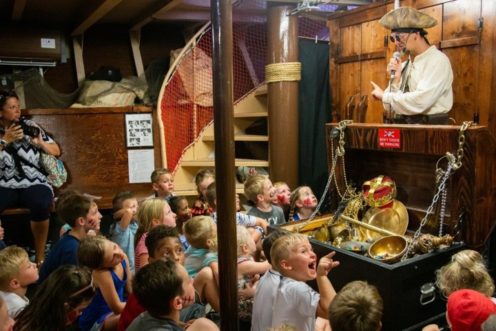 a group of kids hearing a pirate's tale of buried treasure